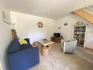 a living room with a blue couch and a table at Semi-detached house, Lancheres in Lanchères