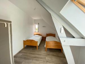 a attic room with two beds and a staircase at Semi-detached house, Lancheres in Lanchères