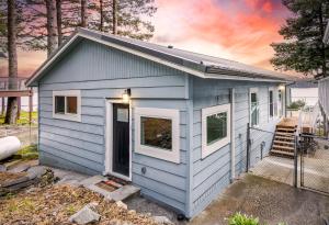 a blue tiny house in a yard at The Cliffside Poustinia in Kodiak