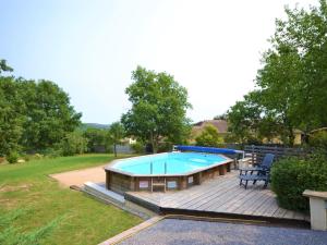 een zwembad met een terras en een bank ernaast bij Alluring Holiday Home in Largenti re with Pool in Largentière