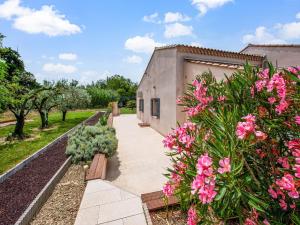 un jardín con flores rosas y un edificio en Holiday Home in Vaucluse near Mont Ventoux, en Pernes-les-Fontaines