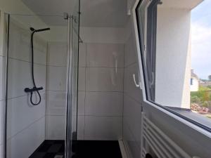 a glass shower in a bathroom with a window at Holiday Home, La Trinite-sur-Mer in La Trinité-sur-Mer