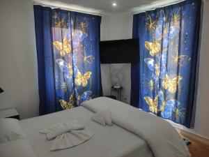 a bedroom with blue curtains with butterflies on them at Memo Moscavide Guest House in Lisbon