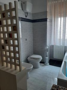 een badkamer met een toilet, een bad en een wastafel bij B&B Lumière in Reggio di Calabria