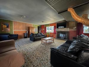 a living room with a couch and a fireplace at The Crossing Lodge & Backpackers in Erua
