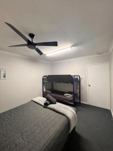 a bedroom with a bed with a ceiling fan at Kalbarri Inn in Kalbarri