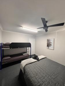um quarto com uma cama e uma ventoinha de tecto em Kalbarri Inn em Kalbarri