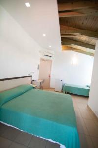 ein Schlafzimmer mit einem grünen Bett in einem Zimmer in der Unterkunft Hotel Marinella in Capo Vaticano