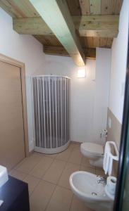 a bathroom with two toilets and a radiator in it at Hotel Marinella in Capo Vaticano