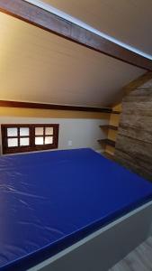 1 cama azul en un dormitorio con pared en Condomínio Maranduba Ville II en Ubatuba