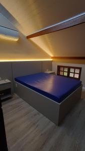 1 dormitorio con 1 cama azul grande en una habitación en Condomínio Maranduba Ville II en Ubatuba