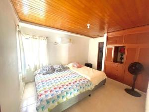 een slaapkamer met een bed, een raam en een ventilator bij HERMOSO APARTAMENTO EN SANTA MARTA in Santa Marta