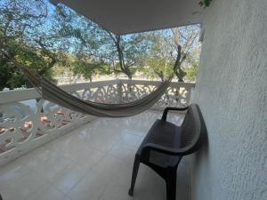 balcón con hamaca y silla en HERMOSO APARTAMENTO EN SANTA MARTA, en Santa Marta