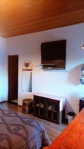 坎普斯杜若爾當的住宿－Styllo Suítes Econômicas，卧室配有一张床和壁挂式平面电视。