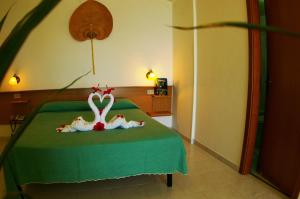 a bedroom with a bed with a swan on it at Hotel Marinella in Capo Vaticano