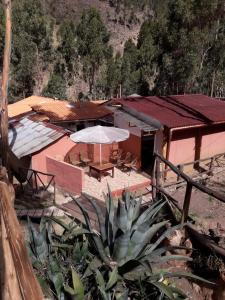 eine Terrasse mit einem Tisch und einem Sonnenschirm vor einem Gebäude in der Unterkunft Casa Turistica Las Tunas in Sicuani