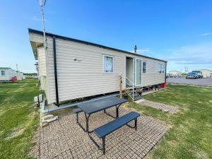 a tiny house with a picnic table in front of it at Modern 6 Berth Caravan With Wifi At St Osyth Beach In Essex Ref 28051fv in Clacton-on-Sea
