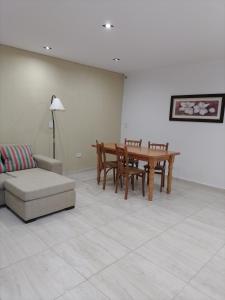ein Wohnzimmer mit einem Tisch und einem Sofa in der Unterkunft RuGra Departamento in Tres Arroyos