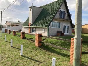 a house with a green roof and a fence at Catador 2 in Barra del Chuy