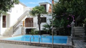 a swimming pool in front of a house at Bell Tower apartments in Tisno