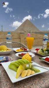 una mesa con platos de frutas y hortalizas. en Pyramids Height Hotel & Pyramids Master Scene Rooftop en El Cairo