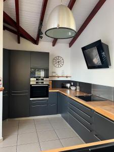 une cuisine avec des placards gris et un plafond dans l'établissement VILLA HAPPY - Le Gosier, au Gosier