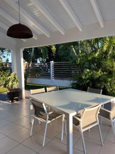 - une table et des chaises blanches sur la terrasse dans l'établissement VILLA HAPPY - Le Gosier, au Gosier