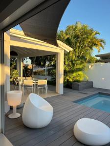 une terrasse avec mobilier blanc et une piscine dans l'établissement VILLA HAPPY - Le Gosier, au Gosier