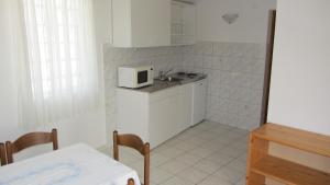 a small kitchen with a sink and a microwave at Bell Tower apartments in Tisno