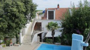 a villa with a swimming pool and a house at Bell Tower apartments in Tisno +57 photos