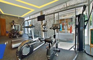 a gym with a treadmill and a bike in a room at Aleenta Resort And Spa, Phuket-Phangnga - SHA Plus in Natai Beach