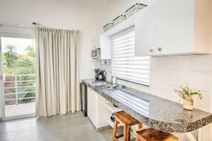 a white kitchen with a counter and a window at Las Vueltas - Golden Zone Studio 2 Blocks to Beach in Bucerías