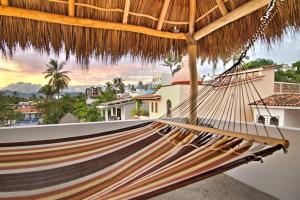 a hammock on a balcony with a view of the city at Las Vueltas - Golden Zone Studio 2 Blocks to Beach in Bucerías