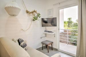 sala de estar con sofá, TV y ventana en Las Vueltas - Golden Zone Studio 2 Blocks to Beach, en Bucerías