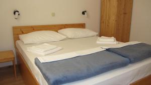 a bed with two white pillows and a blue blanket at Bell Tower apartments in Tisno