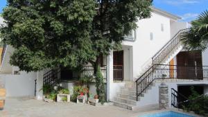a white house with stairs and a tree at Bell Tower apartments in Tisno