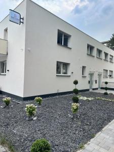 un bâtiment blanc avec des plantes devant lui dans l'établissement EasyLiving Darmstadt, à Darmstadt