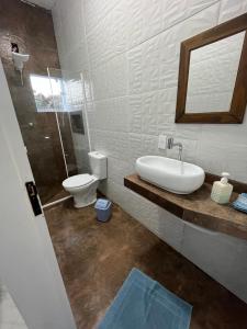 La salle de bains est pourvue d'un lavabo et de toilettes. dans l'établissement Hotel Cidade Paisagem, à Piquete