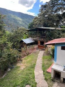 un edificio con un camino junto a una casa en Refugio de Mery Lucmabamba, en Sahuayacu