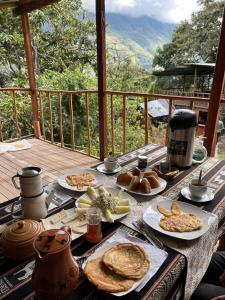 una mesa cubierta con platos de comida en el balcón en Refugio de Mery Lucmabamba, en Sahuayacu