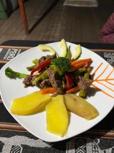 un plato de comida con carne y verduras en una mesa en Refugio de Mery Lucmabamba, en Sahuayacu