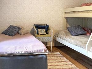 1 Schlafzimmer mit 2 Etagenbetten und einem Stuhl in der Unterkunft Holiday home VALDEMARSVIK VIII in Valdemarsvik