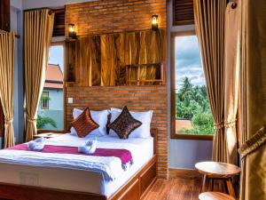 a bedroom with a bed with a large window at LA PETITE MANGROVE Resort in Phumĭ Srângam