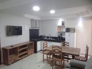 a kitchen with a table and a dining room at Apts e suites em Stella Maris in Salvador