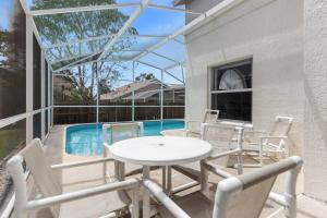 a patio with a table and chairs next to a swimming pool at 2974 Viscount Villa 3bed+ Pool&Spa in Kissimmee