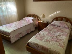 a bedroom with two beds and a table with a lamp at Agua Viva in Piriápolis +9 photos