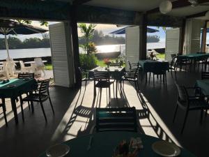 a restaurant with tables and chairs and a view of the water at Madang Resort in Madang