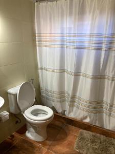a bathroom with a toilet and a shower curtain at Agua Viva in Piriápolis
