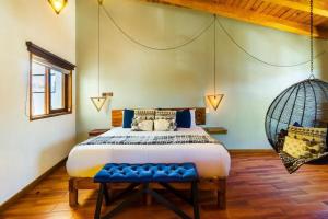 a bedroom with a large bed and a swing at Hotel Kali in Tapalpa