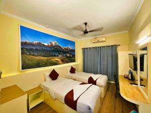 a hotel room with two beds and a painting on the wall at Hotel Peaceland Lumbini in Lumbini